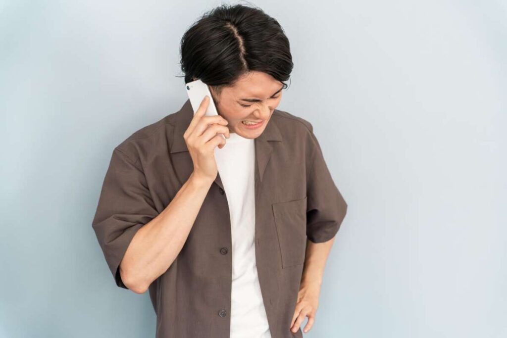 電話しながら苛立つ表情の男性