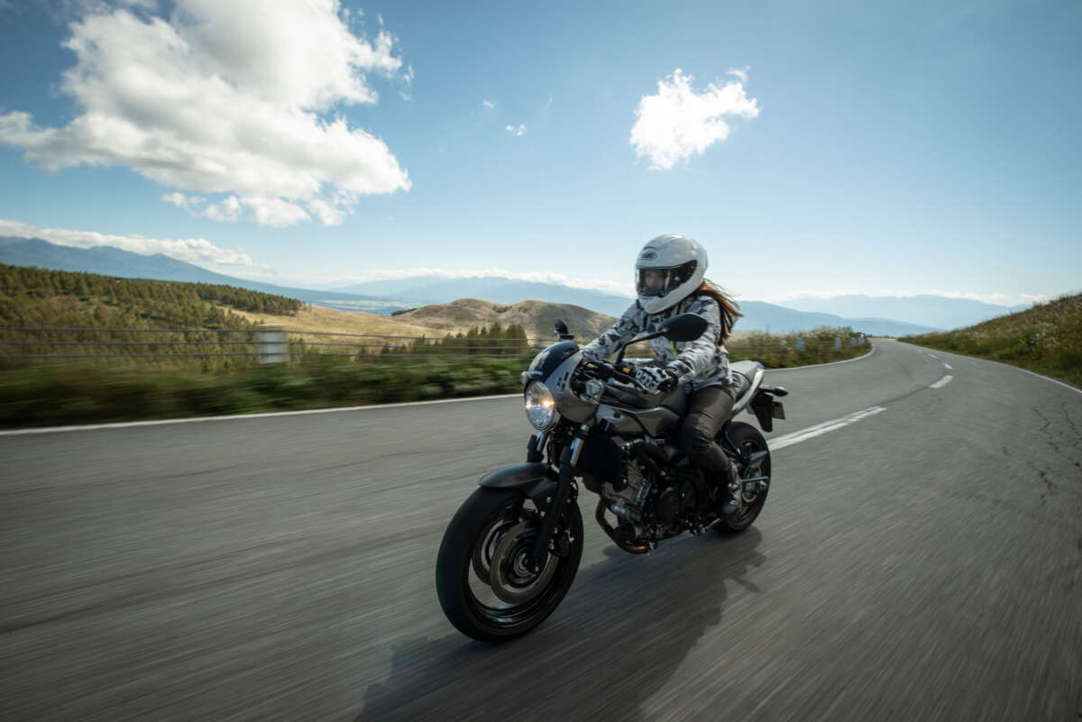 高原道路を走行するネオクラシックバイクとライダー