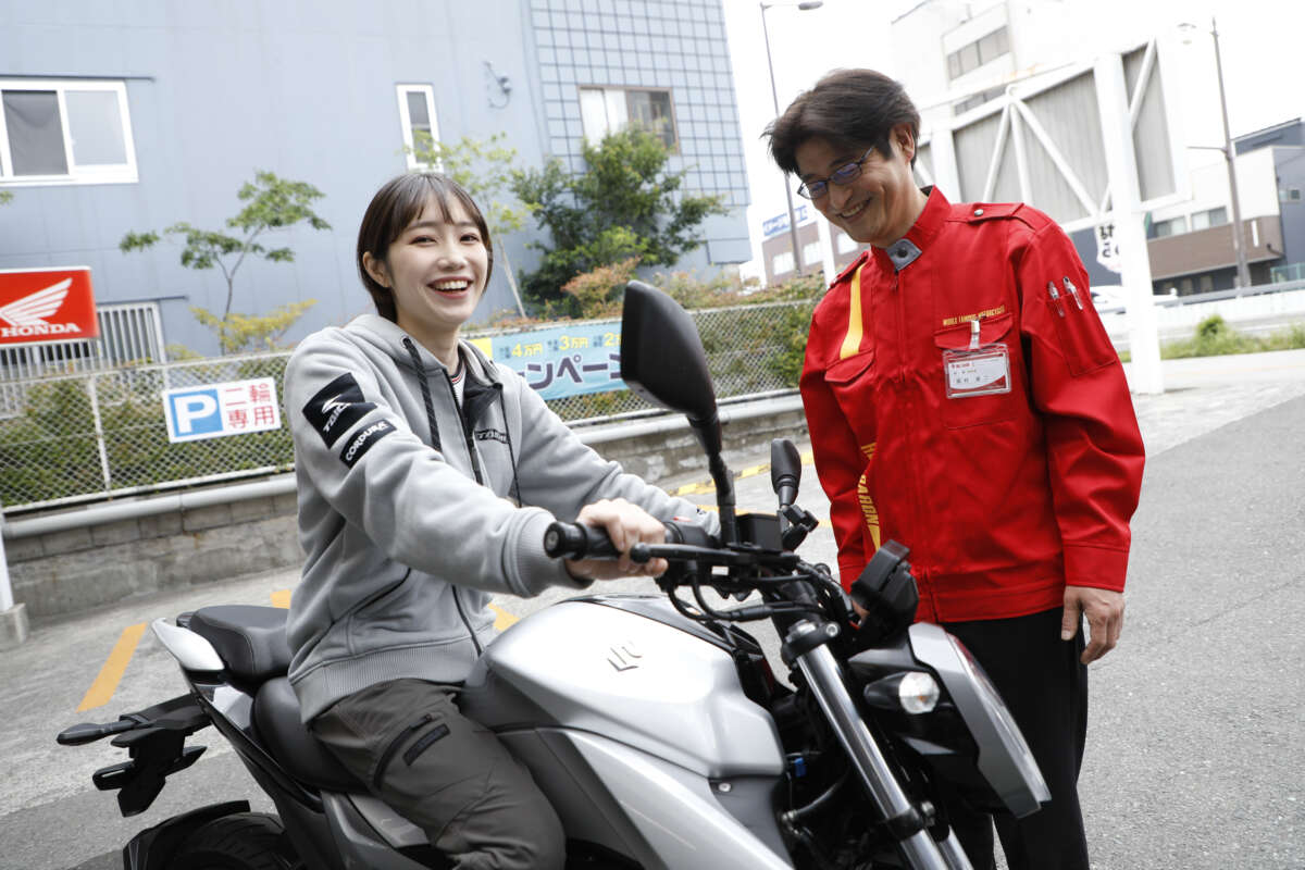 バイクにまたがり笑顔を見せる女性とレッドバロンのスタッフ