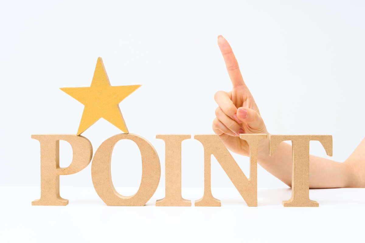 「POINT」の文字と星のオブジェの横で人さし指を立てている