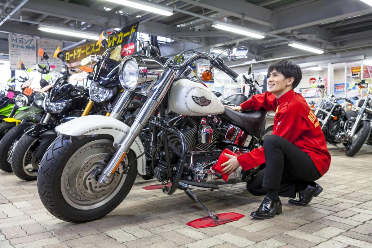 店内でバイクを拭くレッドバロン店員