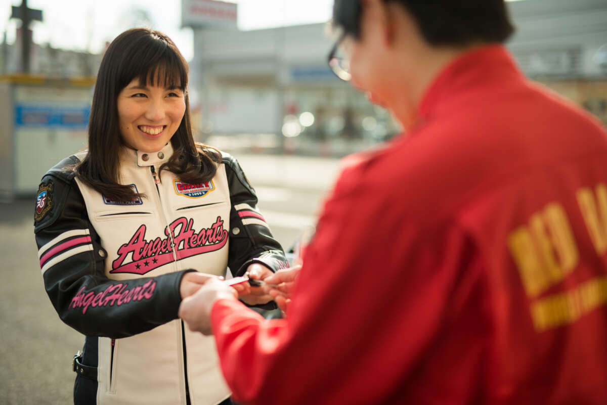 レッドバロンのスタッフと笑顔で鍵を受け渡しする女性
