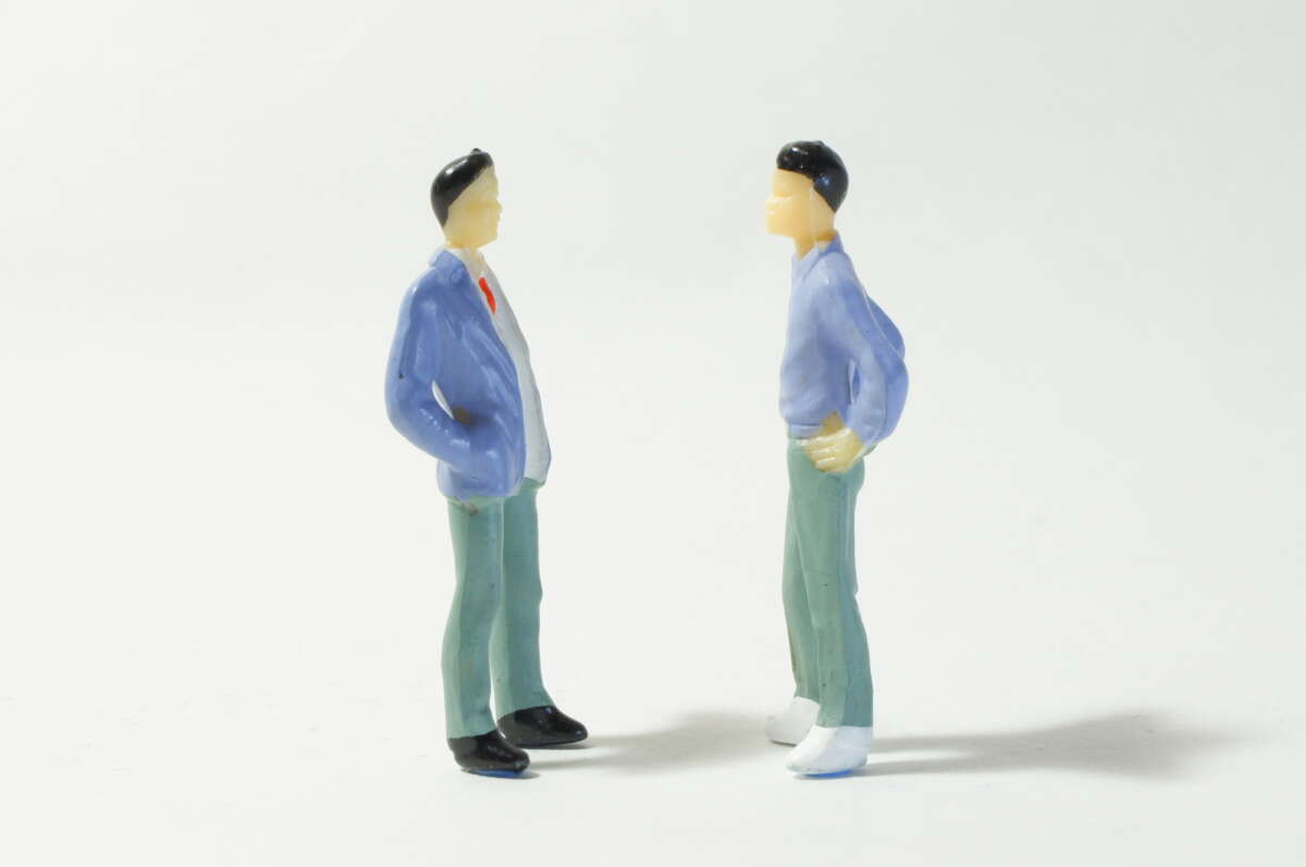 トラブルで向き合う男性2人の人形