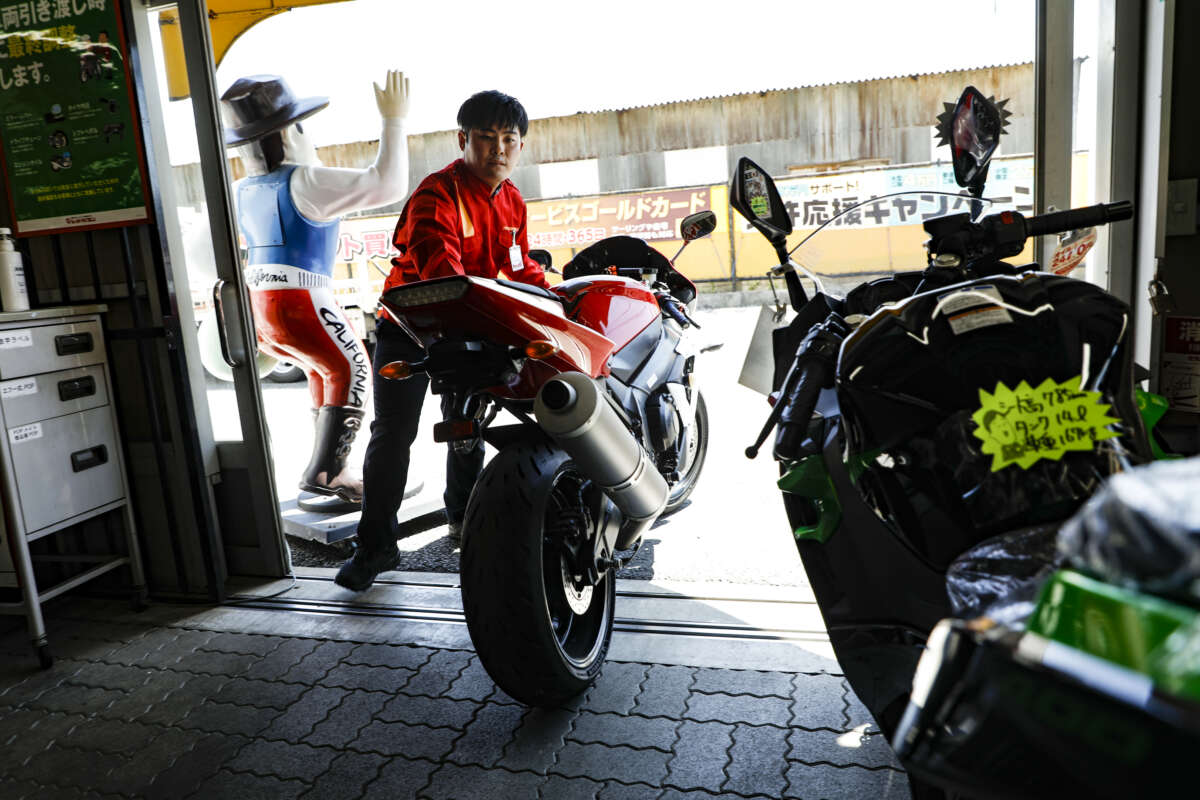 店内にバイクを入れるレッドバロン店員
