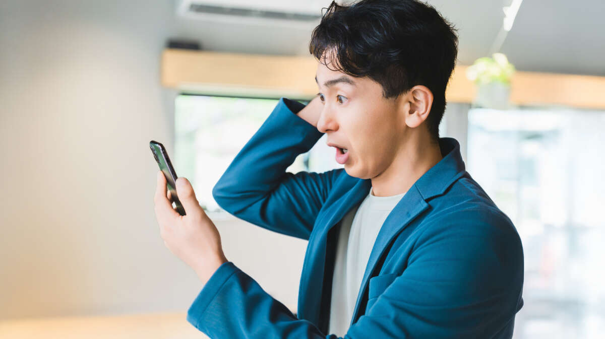 スマホを見て驚く男性