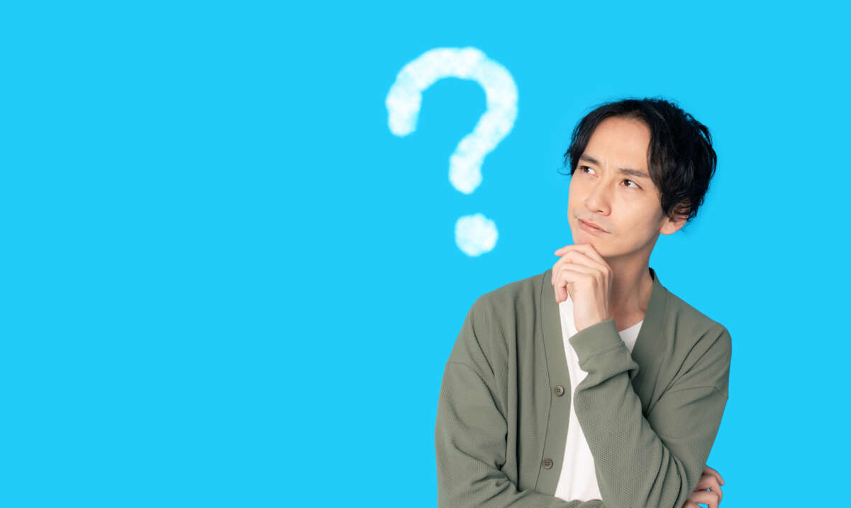 顎に手を当て考える男性と「?」マーク