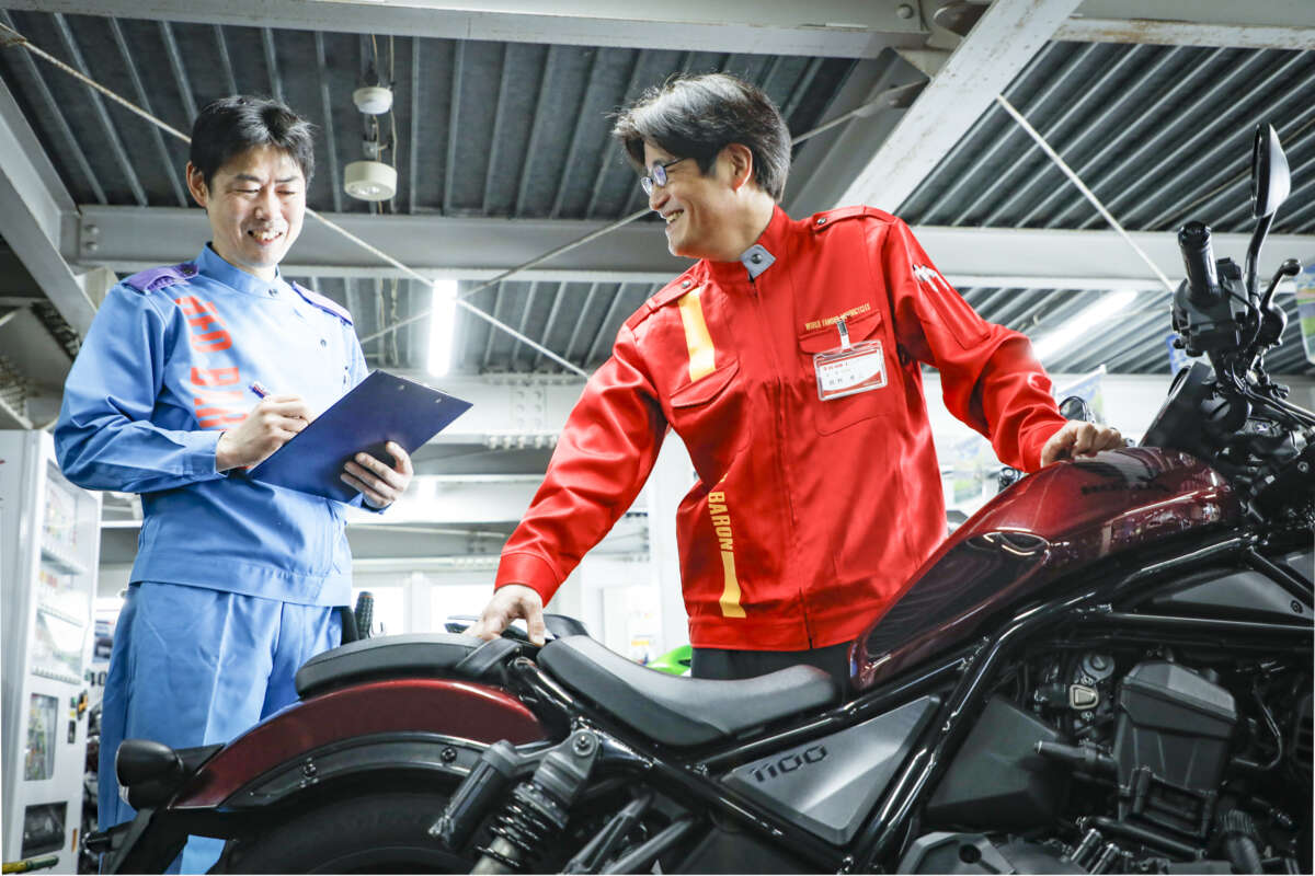 レッドバロンのスタッフたちがバイクを査定しながら談笑している様子