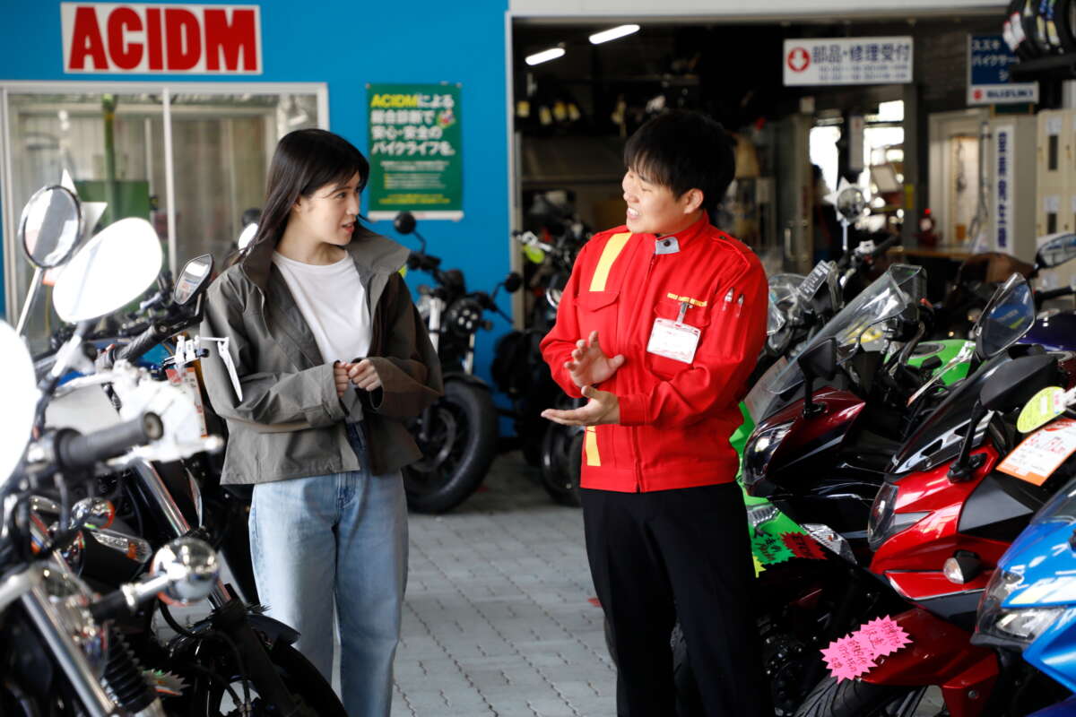レッドバロン店内で従業員から説明を受けている女性客