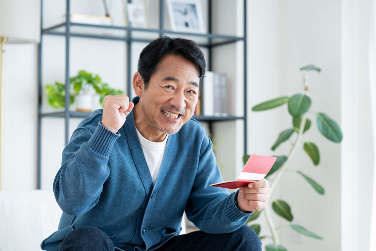 通帳を手に喜ぶ男性