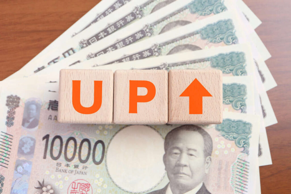 1万円札と「UP↑」と書かれたブロック