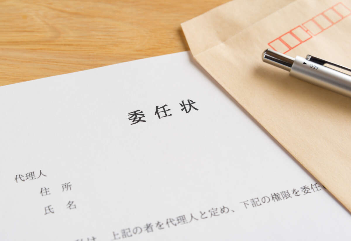 委任状と封筒、ペン