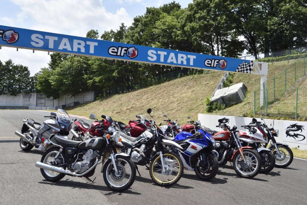 サーキットのスタートゲート下に並べられたさまざまな種類のバイク