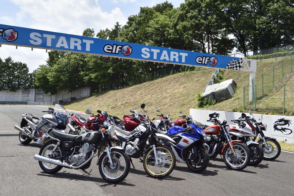 サーキットのスタートゲート下に並べられたさまざまな種類のバイク